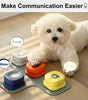 White dog interacting with a set of colorful pet communication devices on a wooden floor.