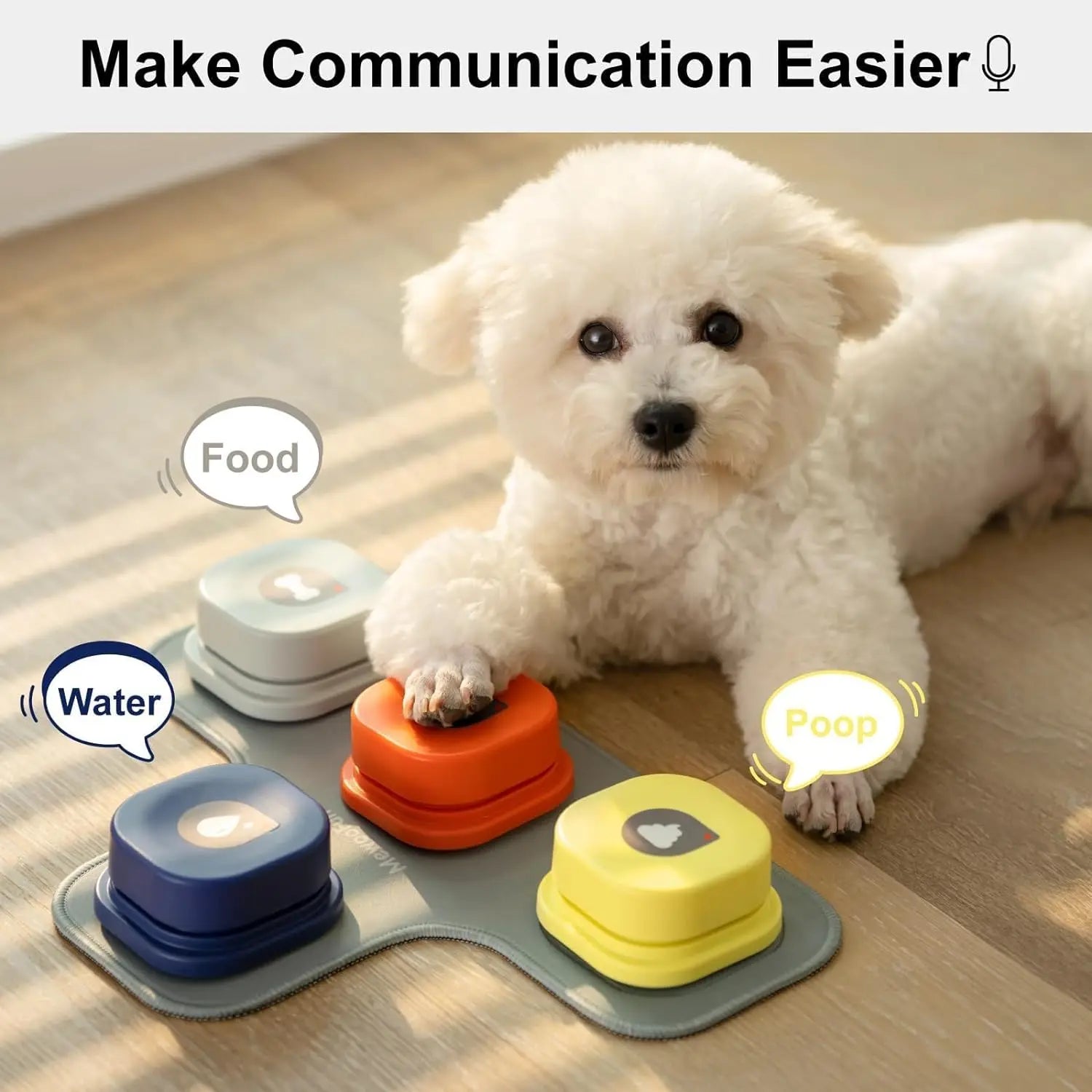 White dog interacting with a set of colorful pet communication devices on a wooden floor.