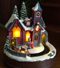 Decorative Christmas scene with a house, trees, and people on a dark background