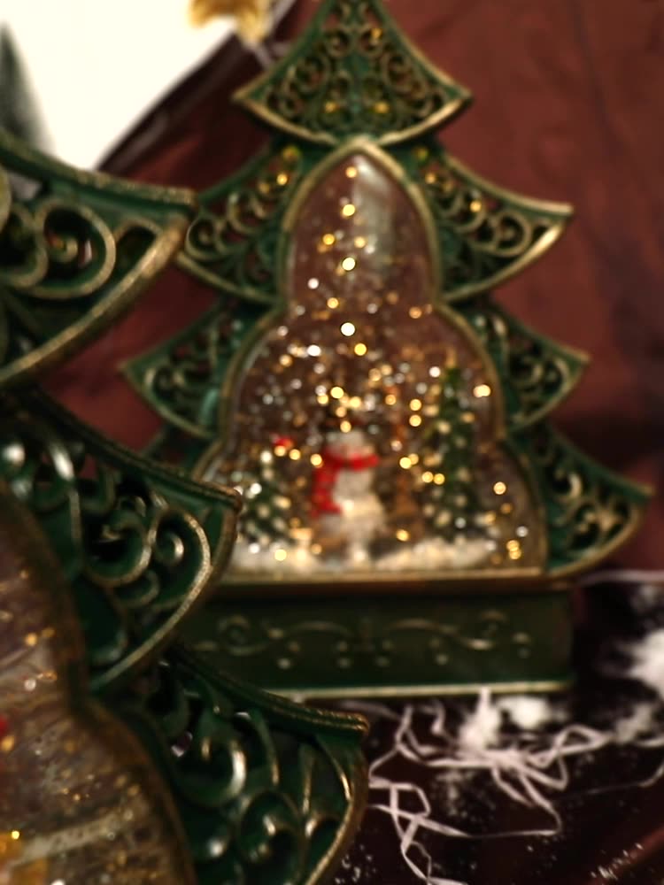 Decorative Christmas tree ornament with a snowman inside a glass dome.