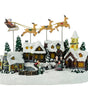 Christmas village scene with Santa's sleigh, houses, and people on a white background