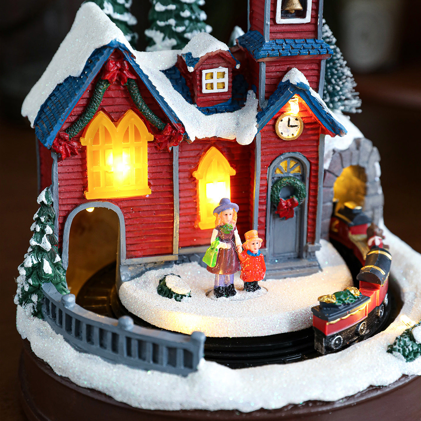 Decorative Christmas scene with a house, children, and a train on a dark background