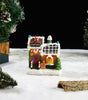 Gingerbread house candy shop model on a snowy landscape with Christmas trees.