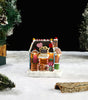 Decorative gingerbread house with candy shop sign on a snowy surface with Christmas trees.