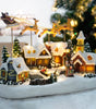 Decorative Christmas village scene with houses, trees, and Santa in a sleigh.