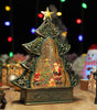 Decorative Christmas tree-shaped snow globe with Santa Claus and ornaments on a wooden surface.