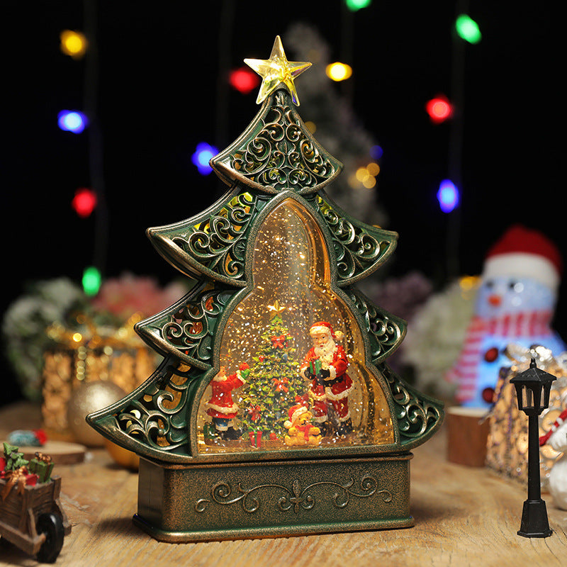 Decorative Christmas tree-shaped snow globe with Santa Claus and ornaments on a wooden surface.