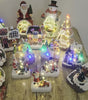 Collection of small, illuminated decorative items on a wooden table.