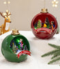 Two Christmas-themed ball ornaments with Santa Claus and trees on a snowy surface.