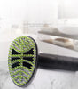 Hairbrush with green bristles on a marble surface