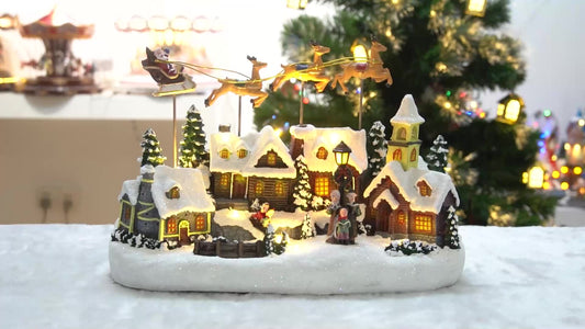 Decorative Christmas village scene with lit houses and trees on a snowy base.