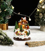 Decorative Christmas scene with a lit-up house, trees, and Santa Claus figure on a snowy base.