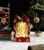 Decorative Christmas light box with a snow globe design, surrounded by festive items.