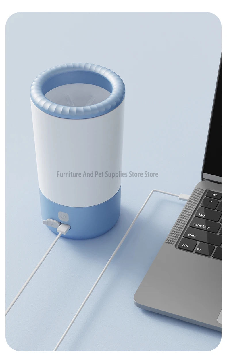 Blue and white pet paw cleaner on a light blue surface next to an open laptop.