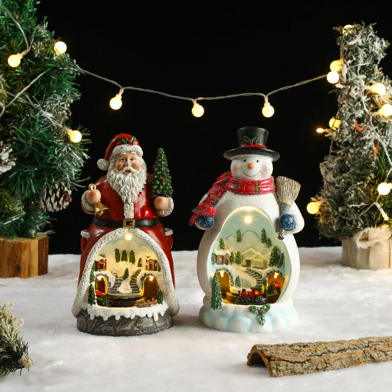 Decorative snow globe figures of Santa Claus and a snowman with Christmas trees and lights in the background.