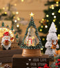 Decorative Christmas tree figurine with a star on top, surrounded by festive decorations.