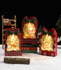Decorative Christmas lanterns in plaid boxes on a snowy background