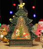 Decorative Christmas tree-shaped snow globe with a glowing interior scene.